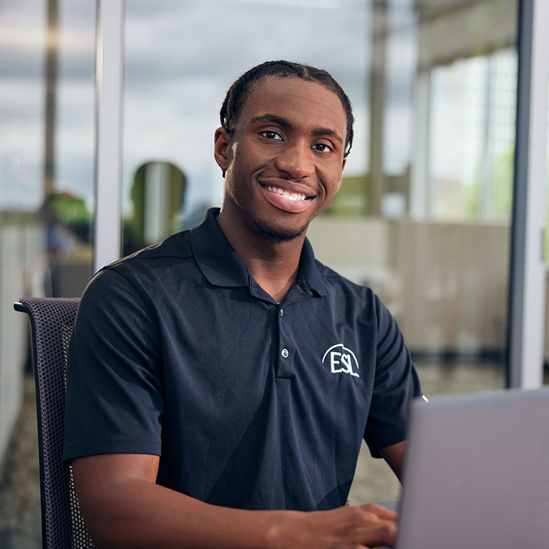 ESL employee working at a table with a laptop