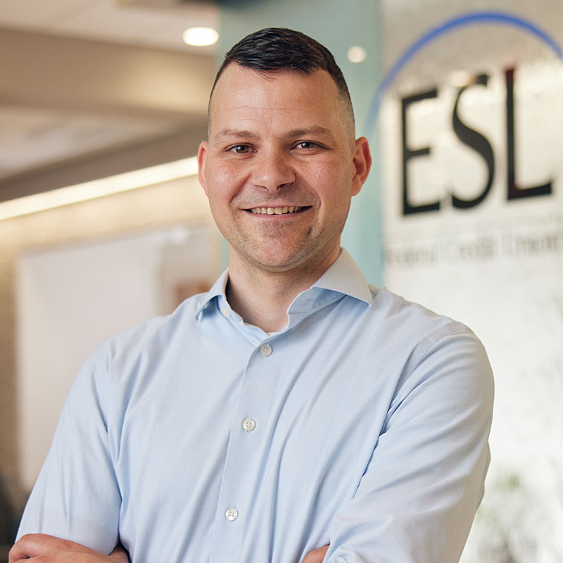 ESL employee standing in front of an ESL sign