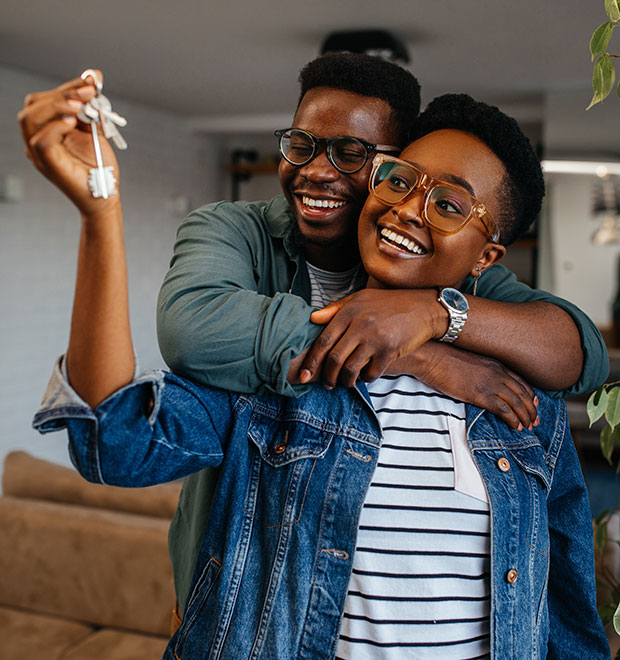 Happy young couple with the keys to their new house.