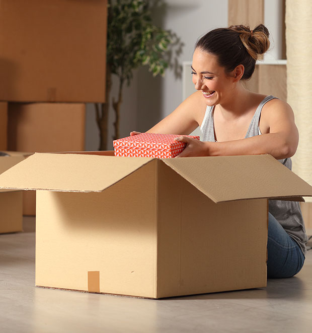 Smiling woman unboxing her belongings in her new home.